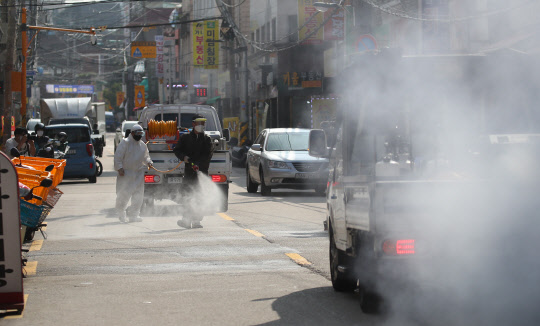 18일 오후 서울 성북구 장위2동 사랑제일교회 인근 도로에서 장위동 상인, 주민, 공무원 등이 합동 방역 활동을 벌이고 있다.  연합뉴스